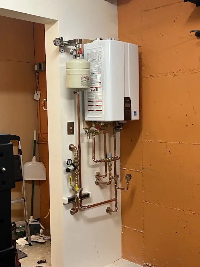 Plumbing technician inspecting water heater connections in Moon Lake